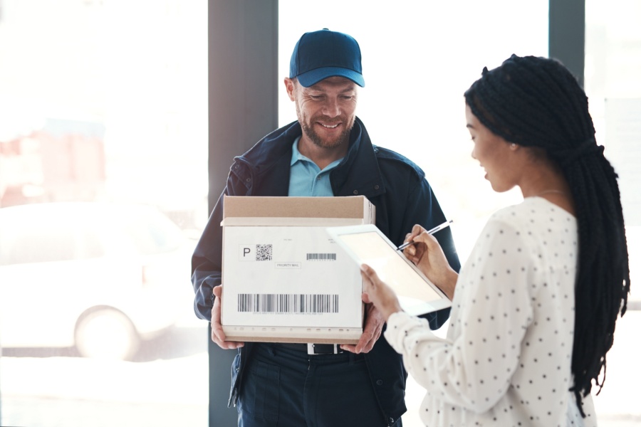 A delivery driver delivers a package to a customer who ordered it via an online e-commerce store.