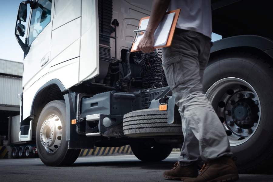 A mechanic works on the engine of a commercial truck.