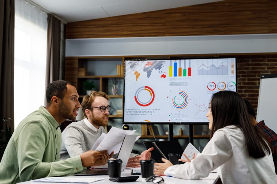 A group of young business people is meeting to discuss predictive analytics solutions