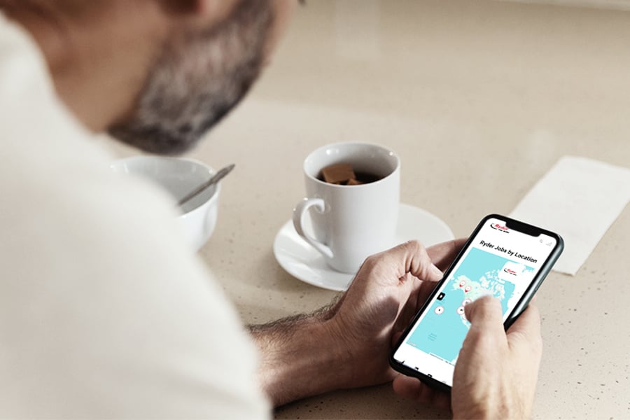 Person searching Ryder jobs by location on a smartphone over coffee Person searching Ryder jobs by location on a smartphone over coffee