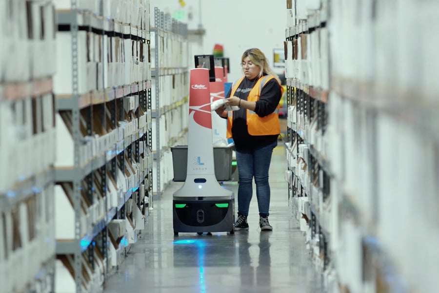 An employee using robots and Rydership technology to sort packages in a Ryder e-commerce fulfillment center