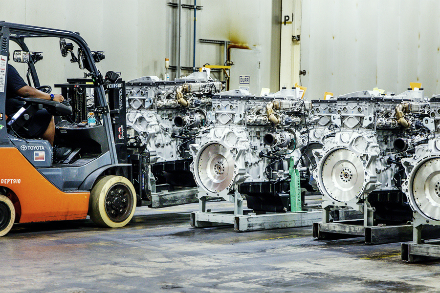 Forklift operator moving automotive engines on pallets in a Ryder manufacturing logistics warehouse Forklift operator moving automotive engines on pallets in a Ryder manufacturing logistics warehouse