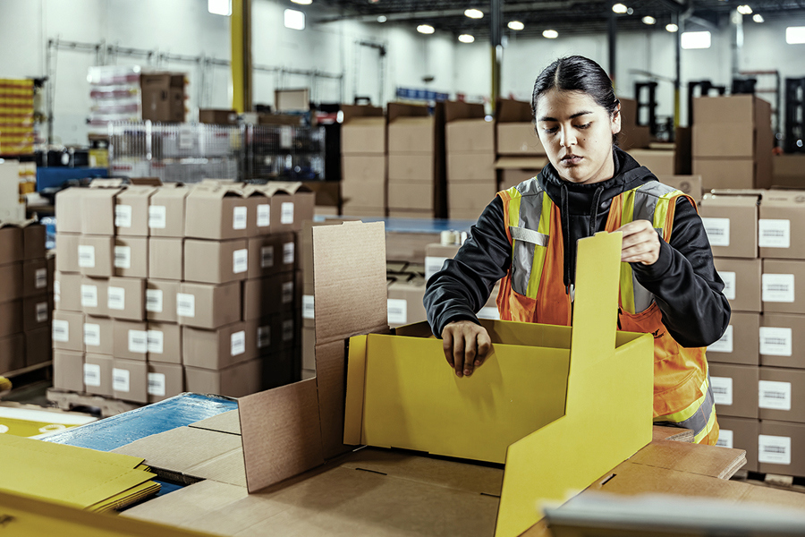 Ryder warehouse associate in a safety vest at a consumer packaged goods packing center
