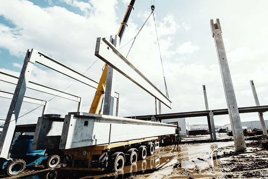 Crane lifting steel beams on a construction site`