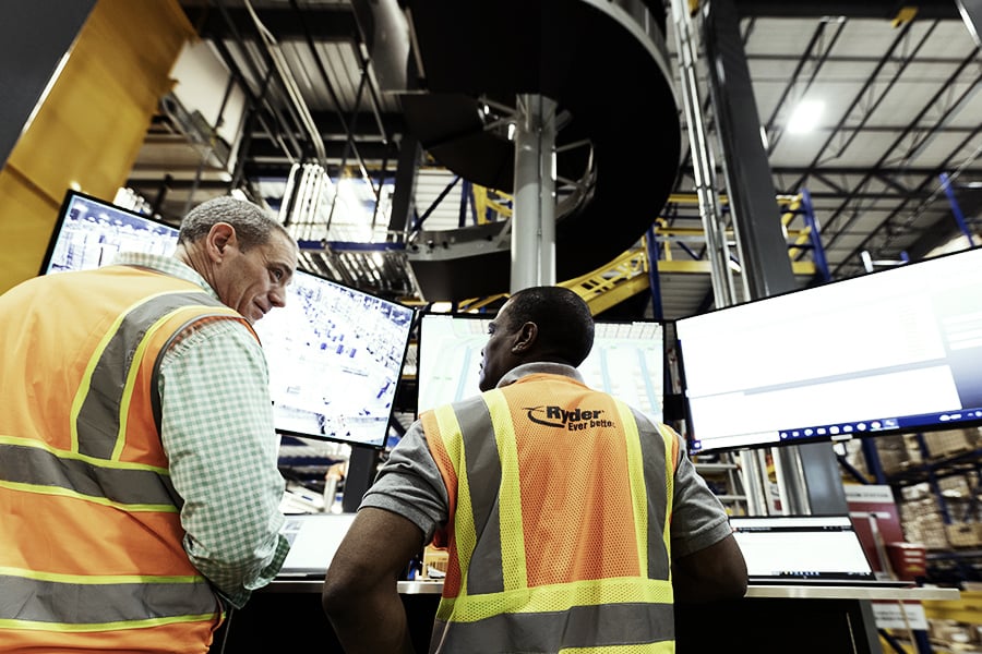 Employees monitoring supply chain operations at a Ryder facility