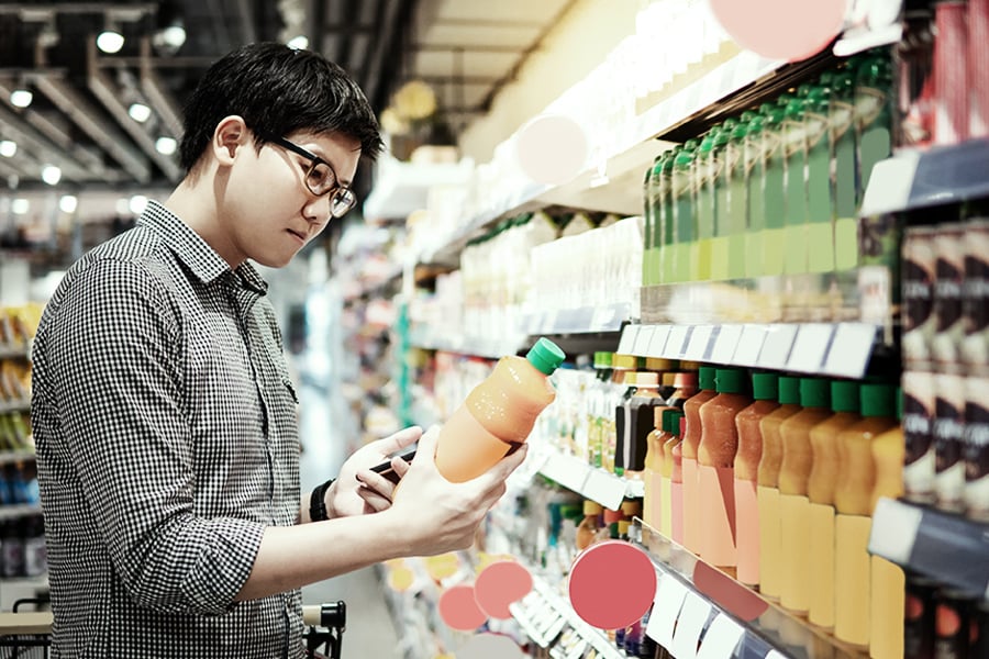 Customer reading the label on a beverage at a supermarket