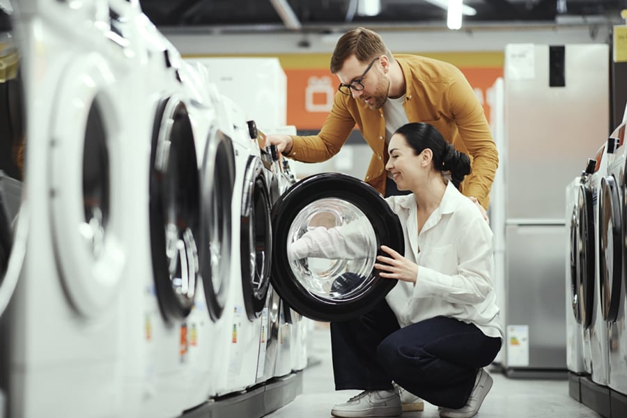 A couple picking out a new washing machine at a department store