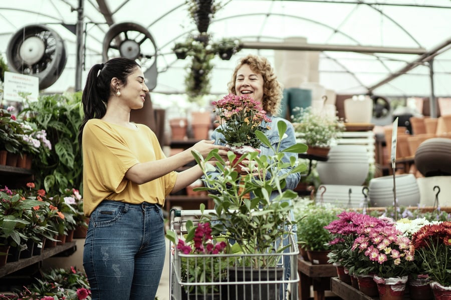 Two friends picking out flowers at a florist