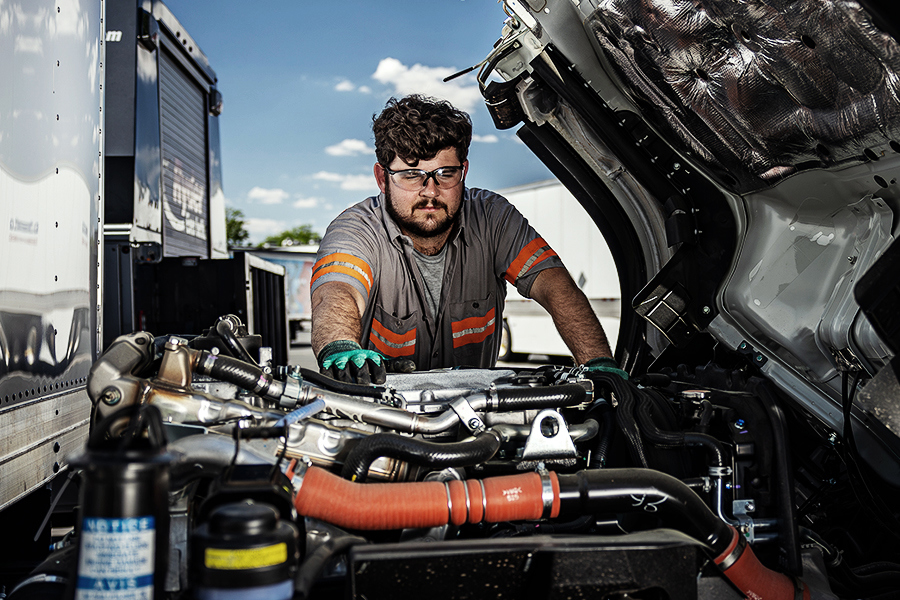 A Ryder mechanic performing on-site maintenance on a customer's semi-truck