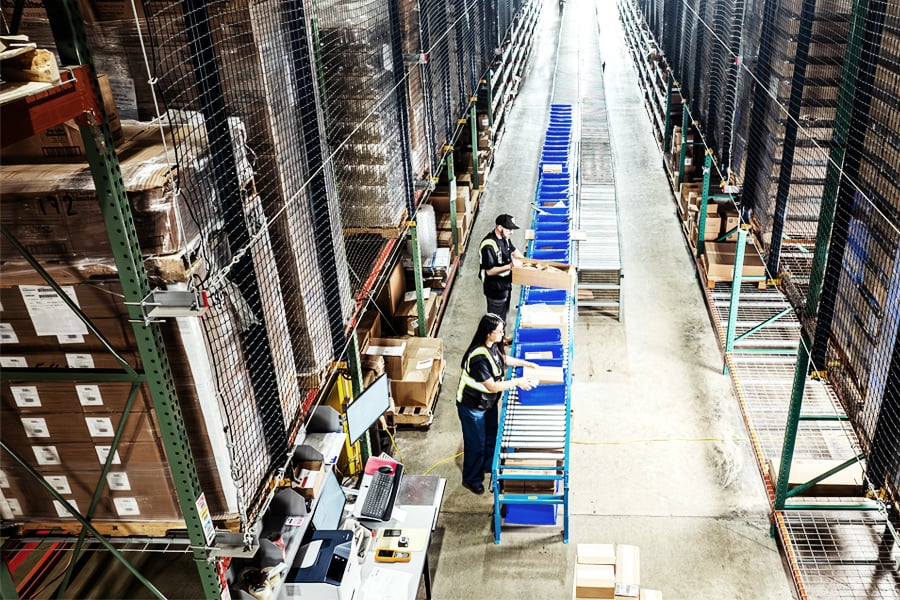 Worker using warehouse management technology to track shared warehouse inventory Worker using warehouse management technology to track shared warehouse inventory