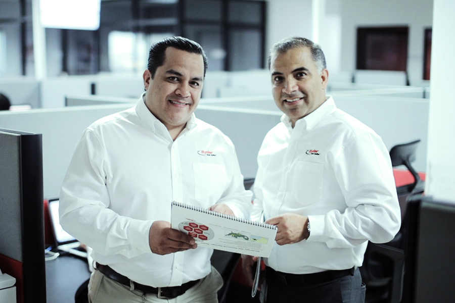 two ryder employees side by side holding a journal with graphs