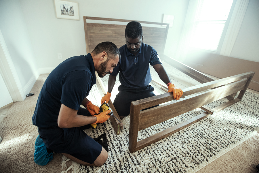 White glove delivery technicians assempling a bed for a customer