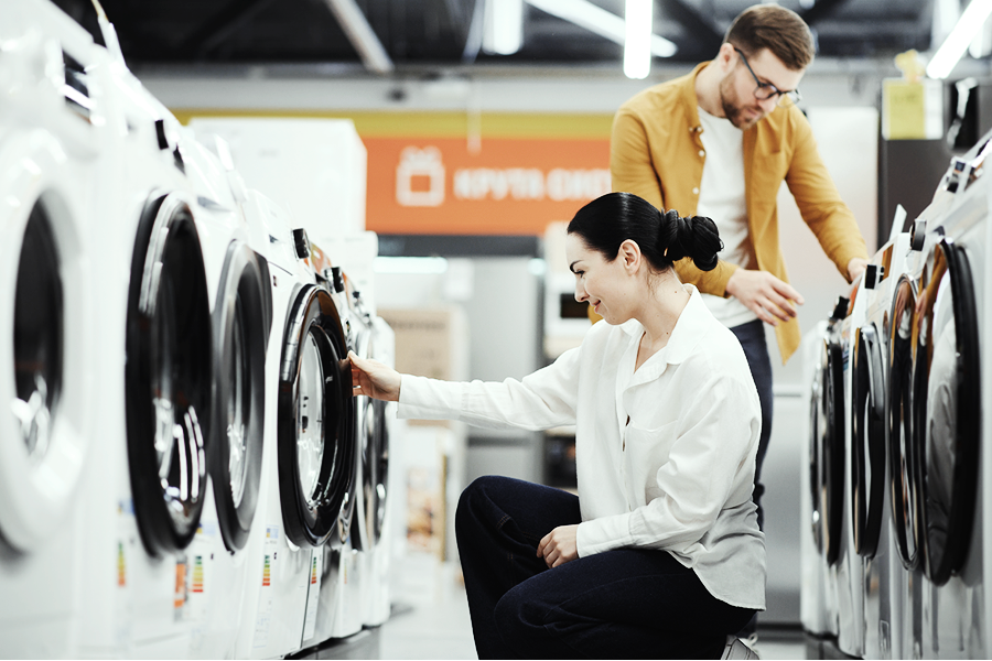 A couple picking out a washing machine at a retail store