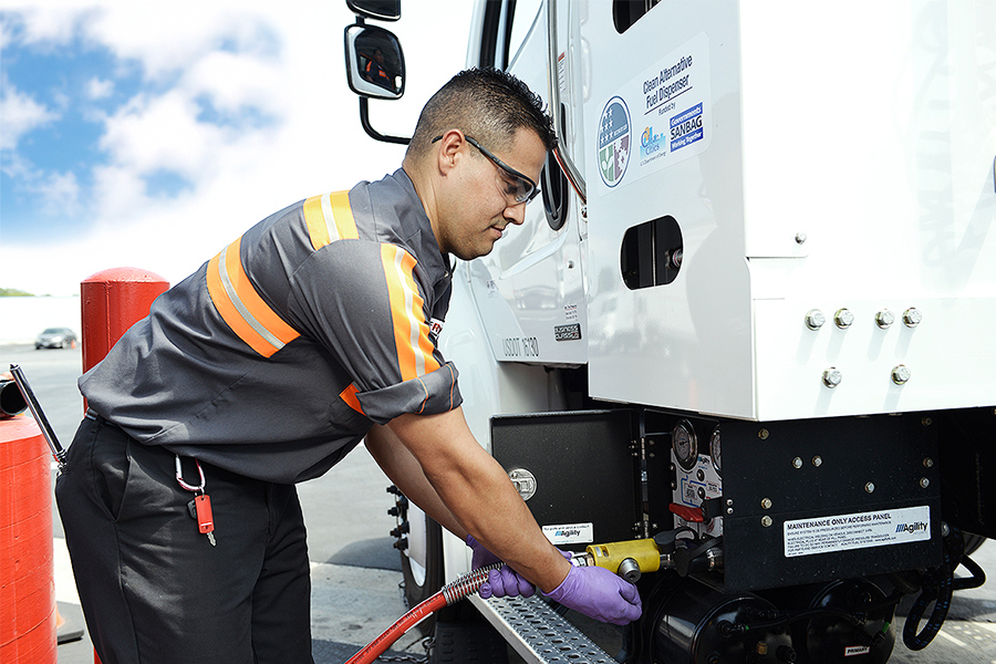 A Ryder technician filling up a semi truck with an alternative fuel