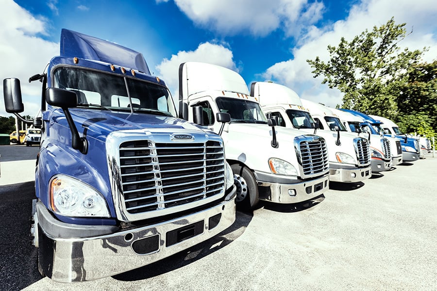 A row of used semi trucks for sale at a Ryder facility.